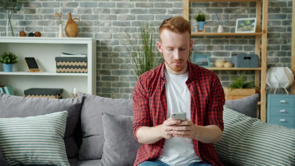 Young man using smartphone at home